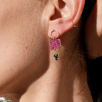 Close-up of a woman wearing pink earrings with a blurred background