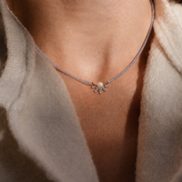 Necklace with a pendant worn by a person, close-up on neck and shoulders.