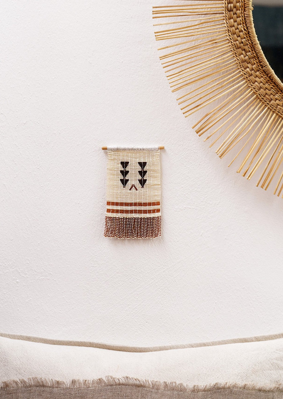 Homeware_ Maasai beaded wall hanging using recycled thread in neutral colour palette. Featured next to People of the suns mirror.