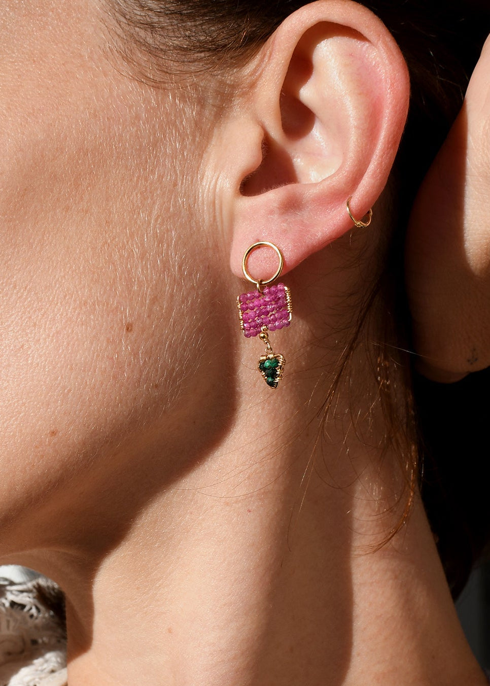 Close-up of a woman wearing pink earrings with a blurred background