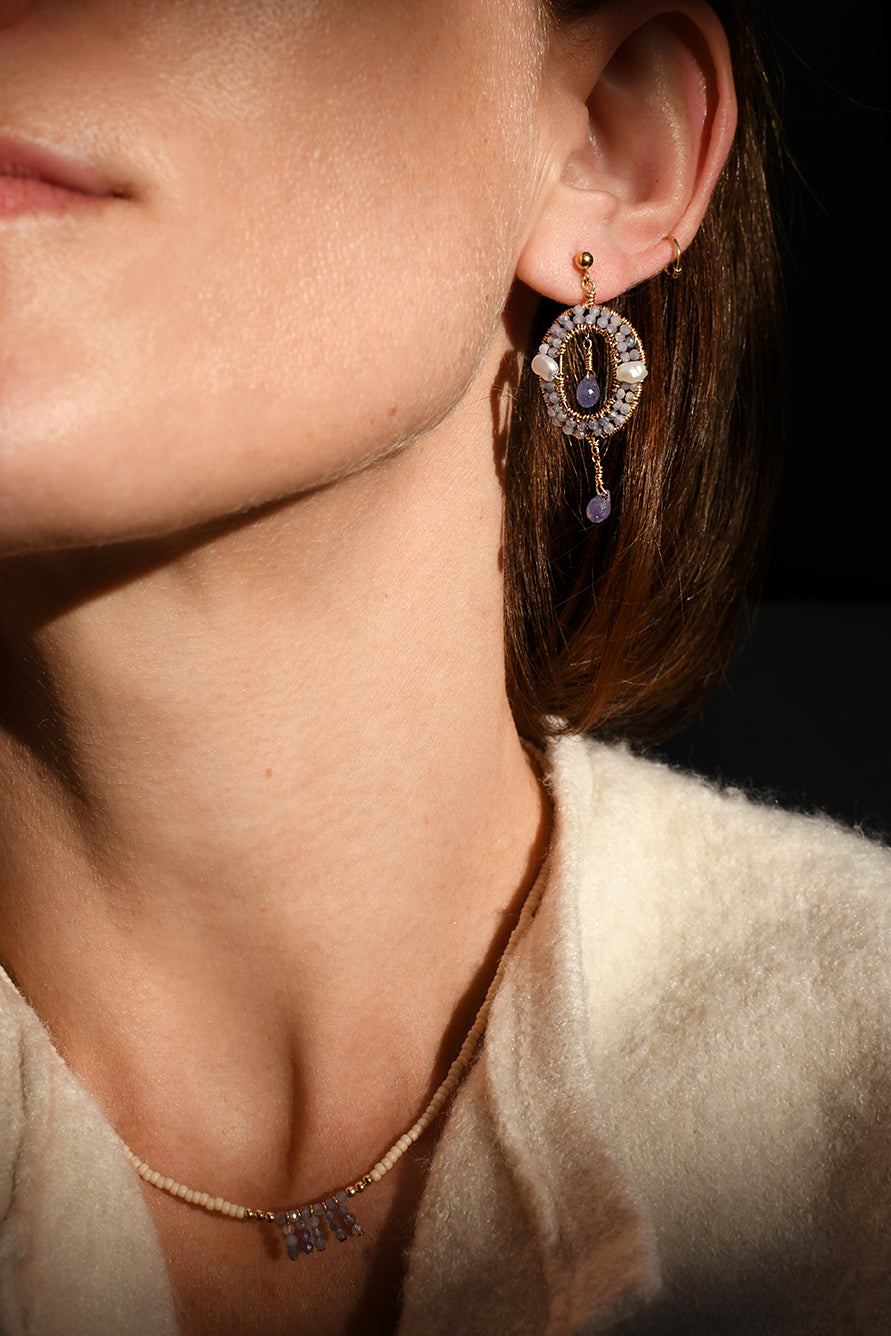Close-up of a person wearing a decorative earring and necklace.