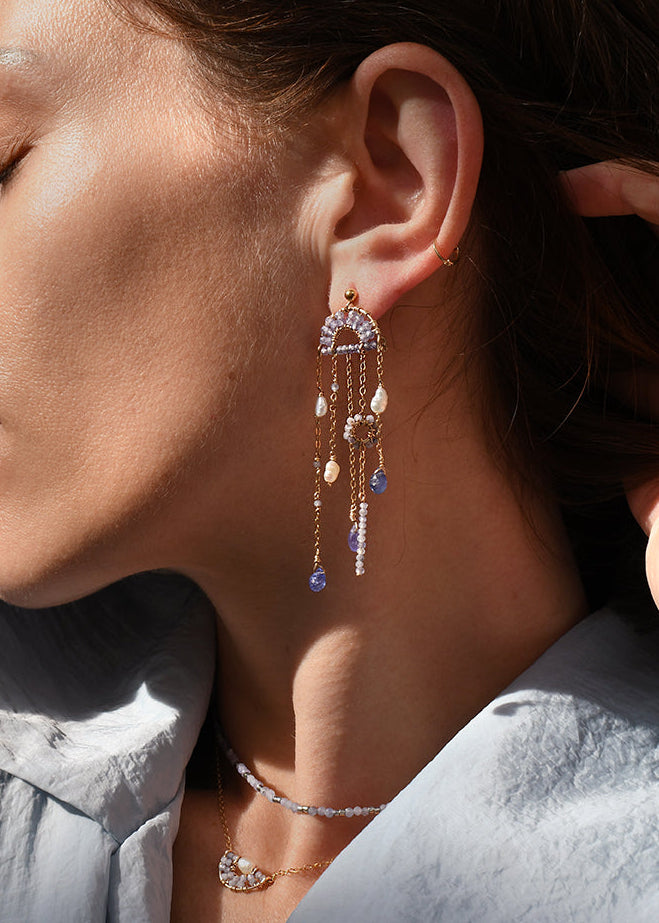 Close-up of a woman wearing elegant earrings with a soft focus on her face.