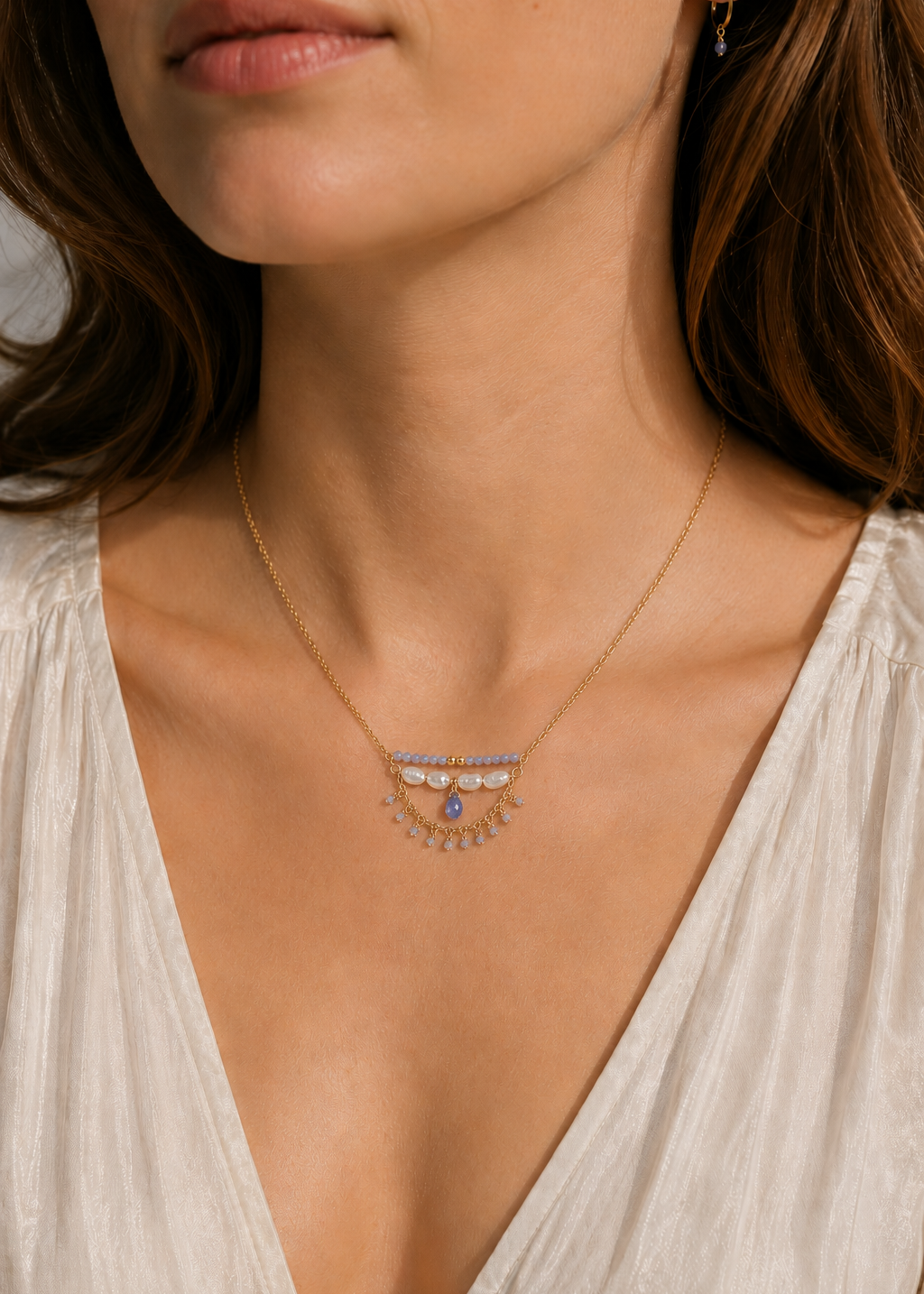 Necklace with gemstones worn by a person in a white top