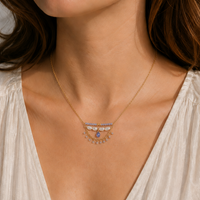 Necklace with gemstones worn by a person in a white top