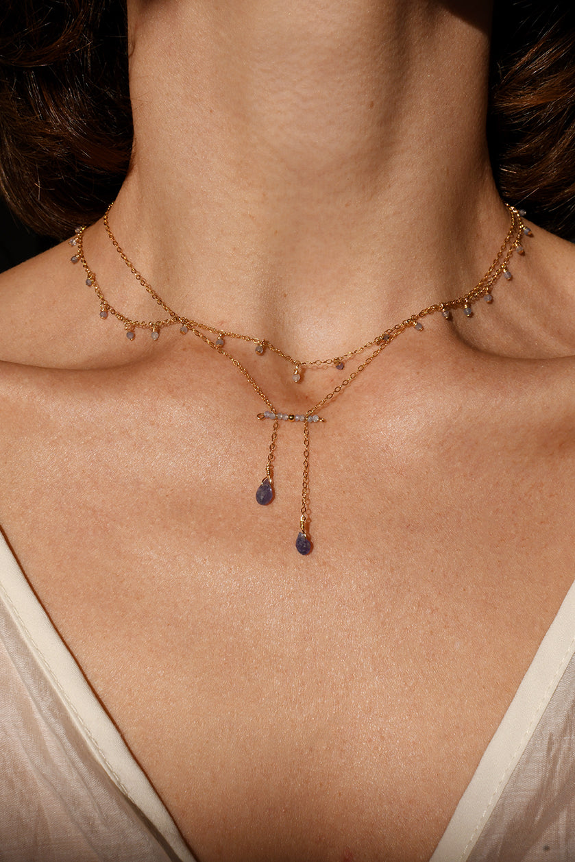 Necklace with small tanzanite stones worn by a person