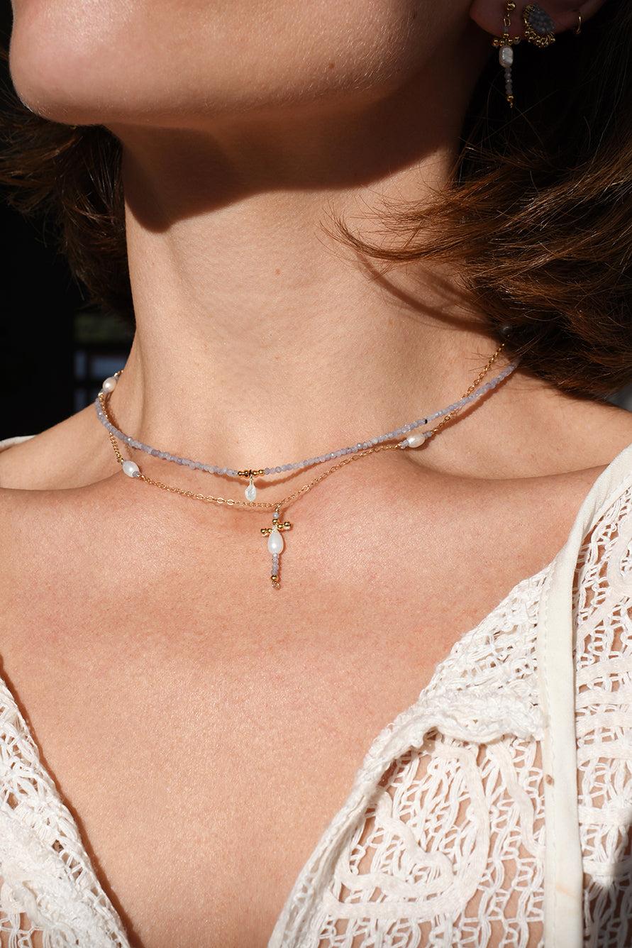 Close-up of a woman wearing multiple necklaces with a blurred background