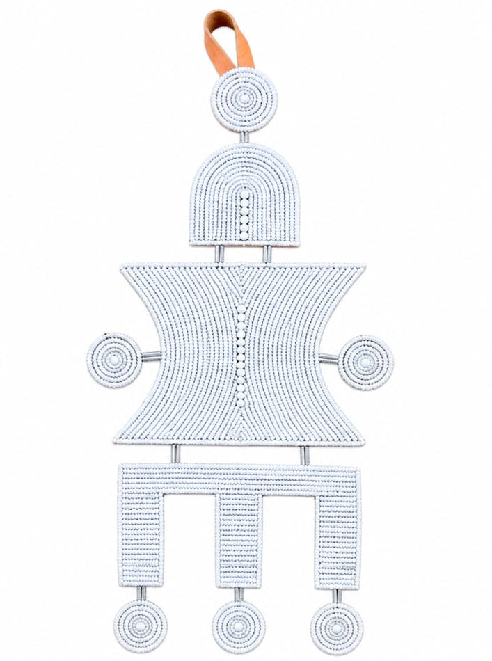 Two African-style beaded hanging ornaments shown side by side on a white background, one in black and one in white, both with tan leather loops at the top.