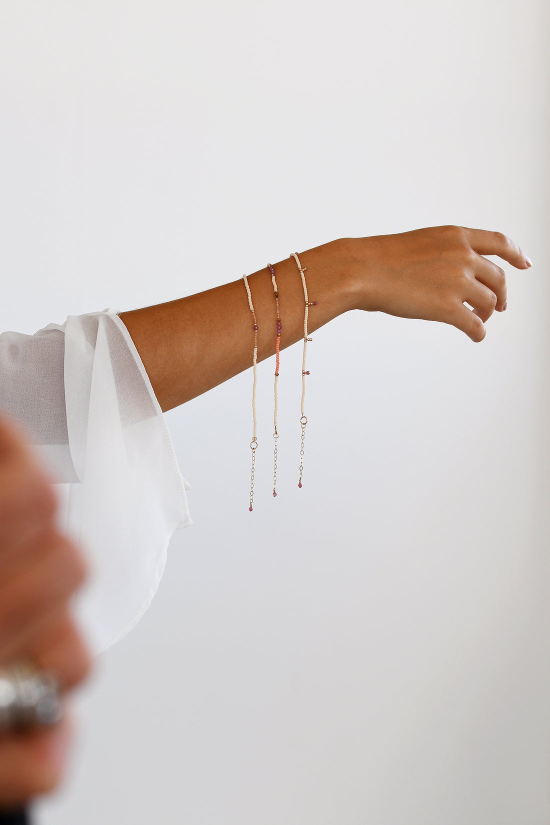 Person wearing a delicate bracelet on a plain background